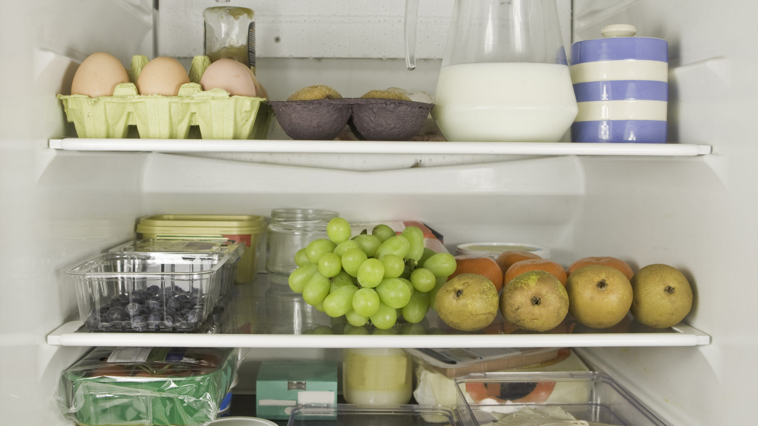 Three refrigerator shelves full of food