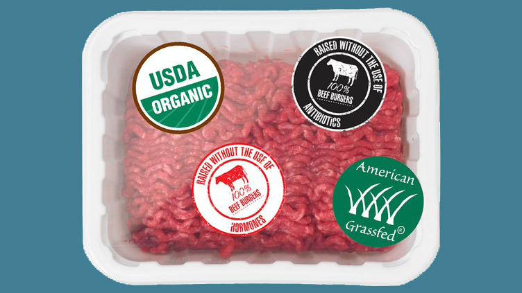 Package of ground beef with four food labels featuring various claims, like "organic" and "grassfed"