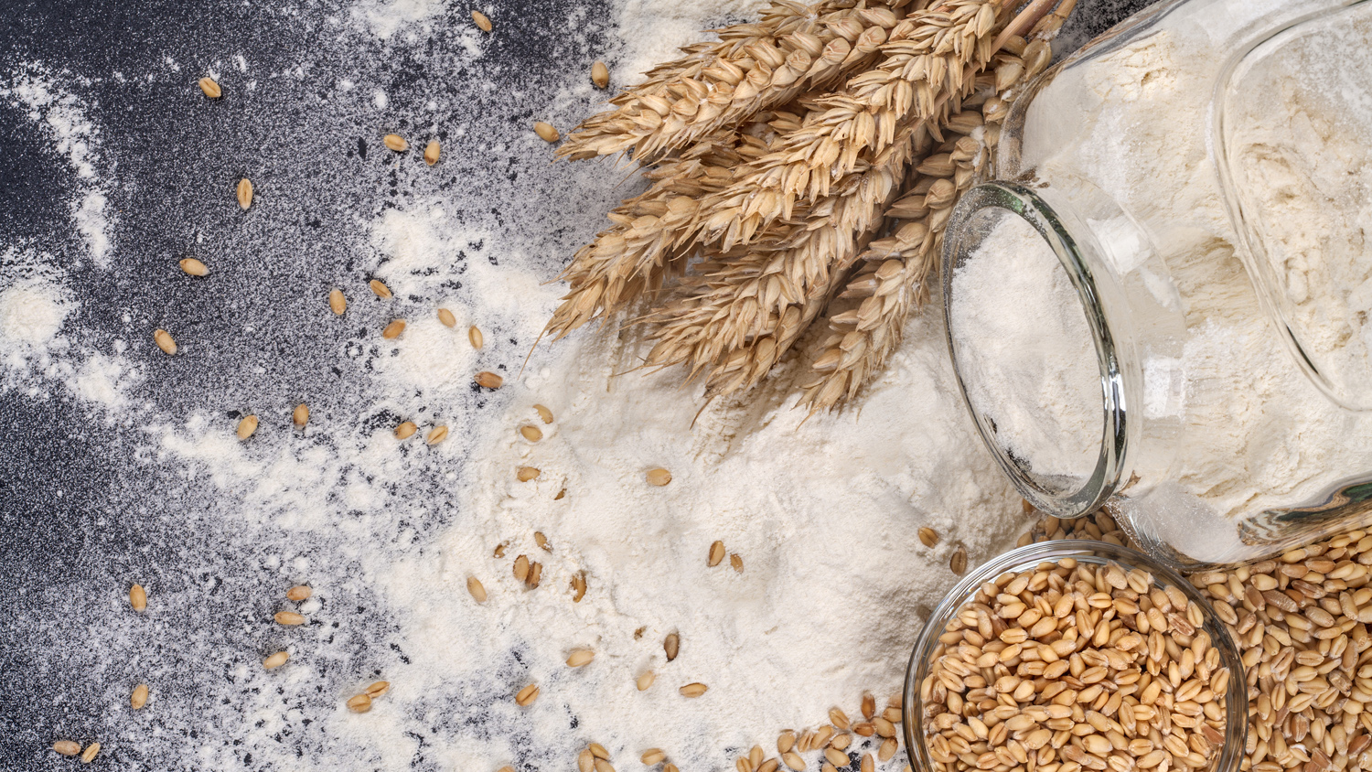 Jars with flour and grain with stalks of wheat