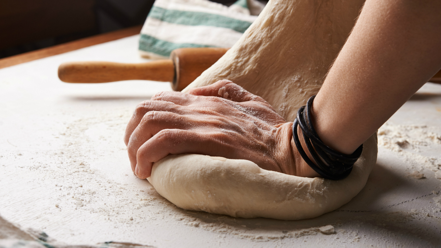 A photo of hands kneading bread