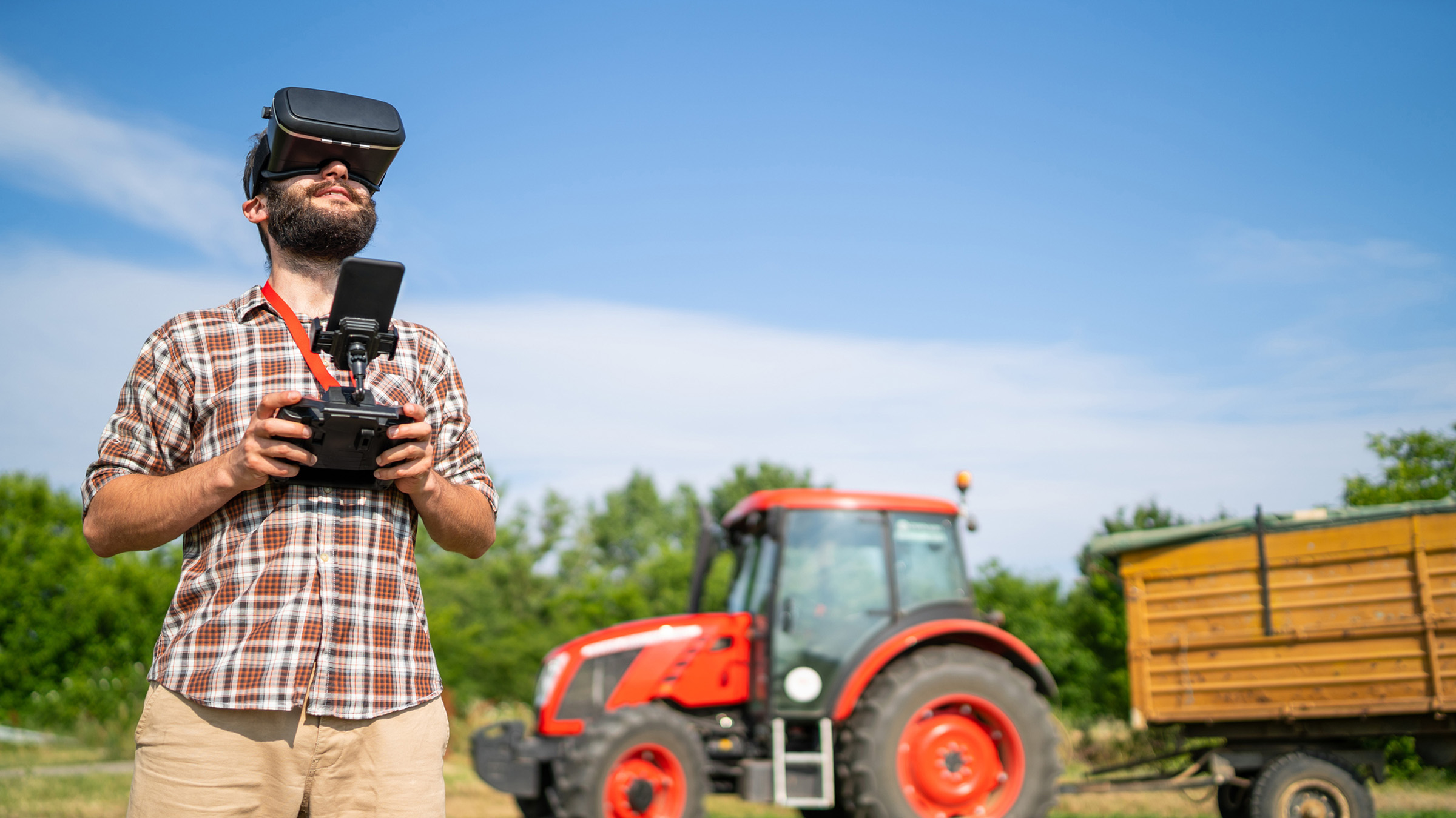 Farmer flying a drone over a field using a VR headset