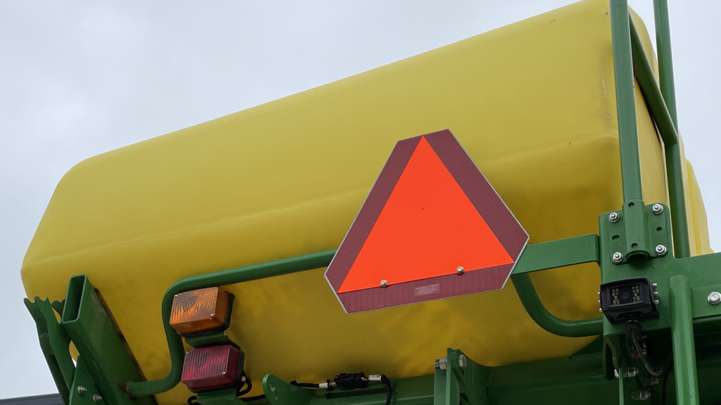 The slow moving vehicle (SMV) sign is a reflective orange triangle bordered with red that warns drivers that the vehicle displaying the sign is unable to maintain a speed of more than 25 mph.
